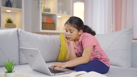 la niña que mira la computadora portátil está desmotivada y aburrida.