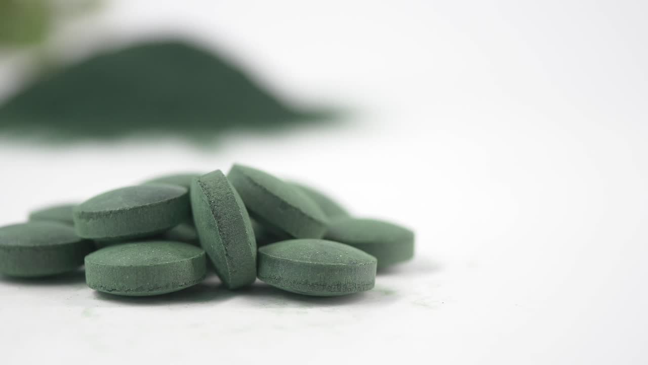 Close-up of Green Spirulina or Chlorella Pills and Powder