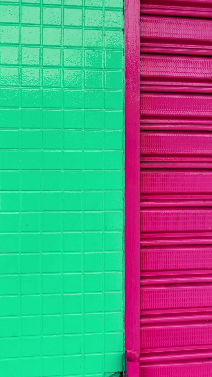 Azulejos verde-brilhantes e persianas magenta