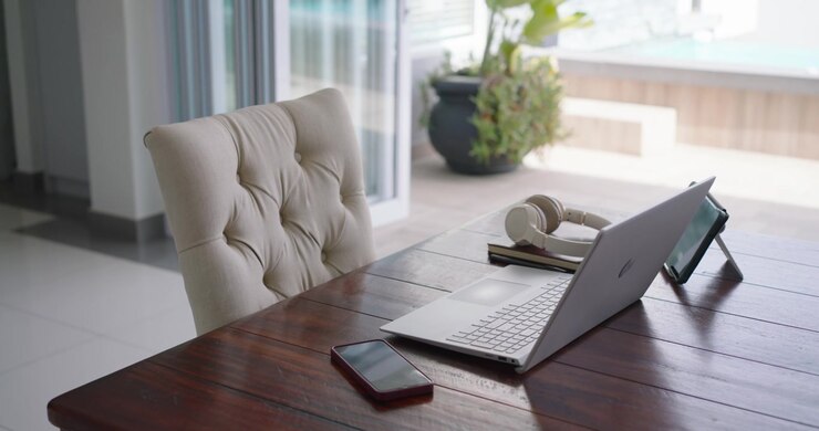 Autofocus is shifting focus, showing empty tufted chair beside laptop and headset near sliding door