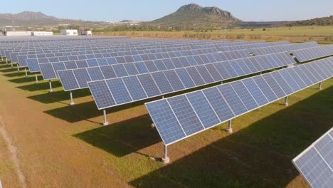 backward low aerial of solar panels in a big solar farm in desert