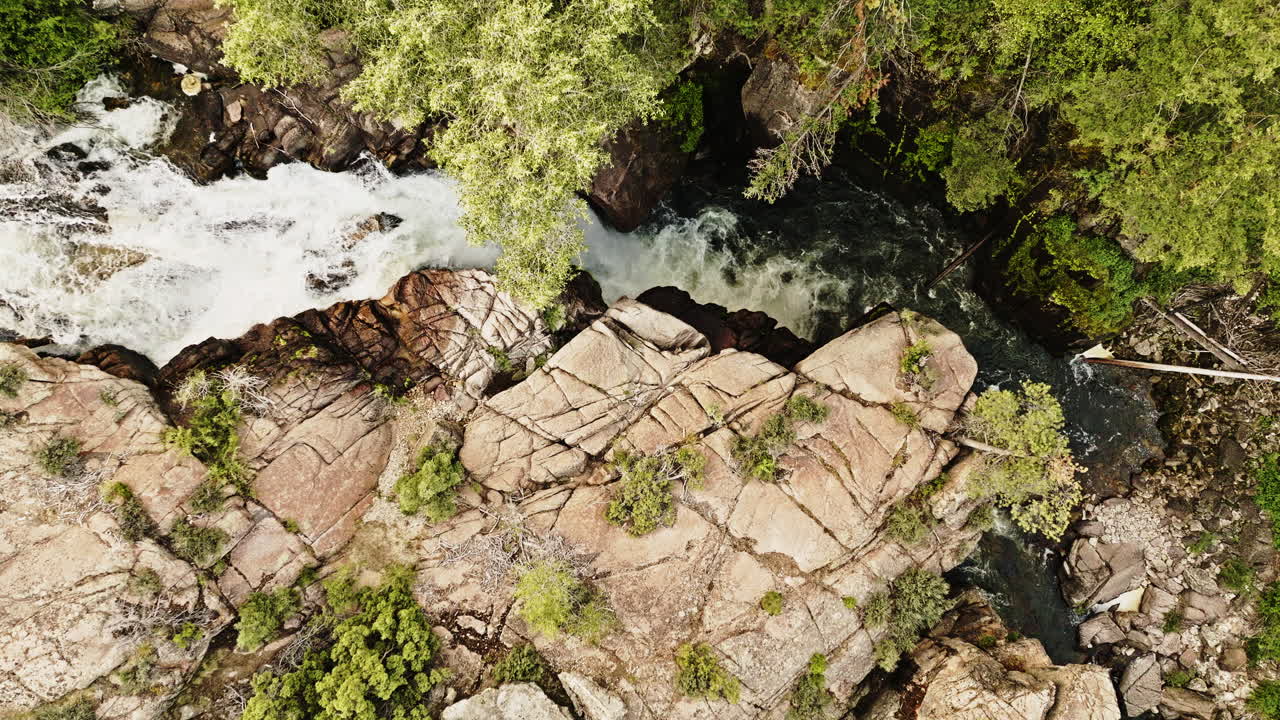 Drone shot looking down on river running through rugged rock formation in the western United States