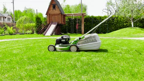 aerial drone view of green lawn-mower on circle of fresh lawn at yard. tools for cutting grass.