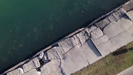 Tiro-De-Drone-De-Giro-Lento-Ascendente-De-Malecón-Roto-A-Lo-Largo-Del-Lago-St