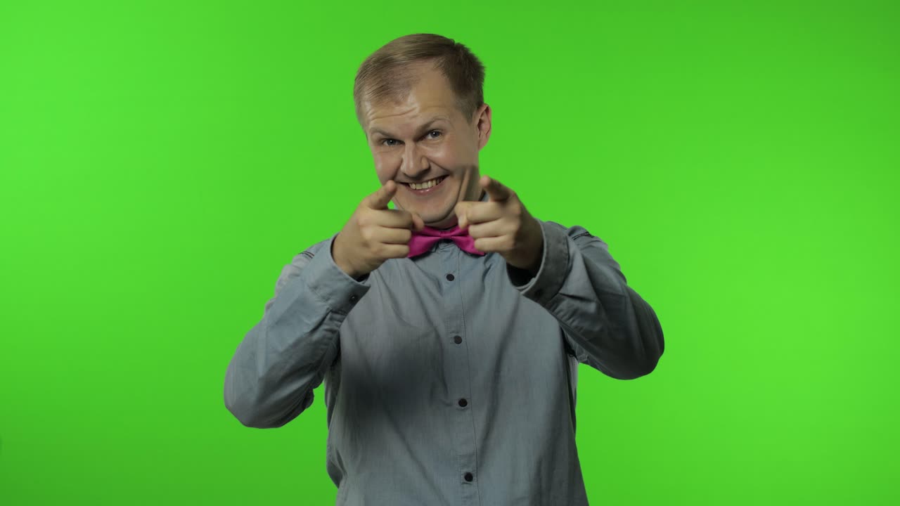 hombre feliz sonriendo a la cámara, riendo despreocupado y señalando con el dedo a la camera, eligiendo algo