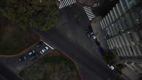 drone flies up from road intersection, cars give way to other cars, traffic