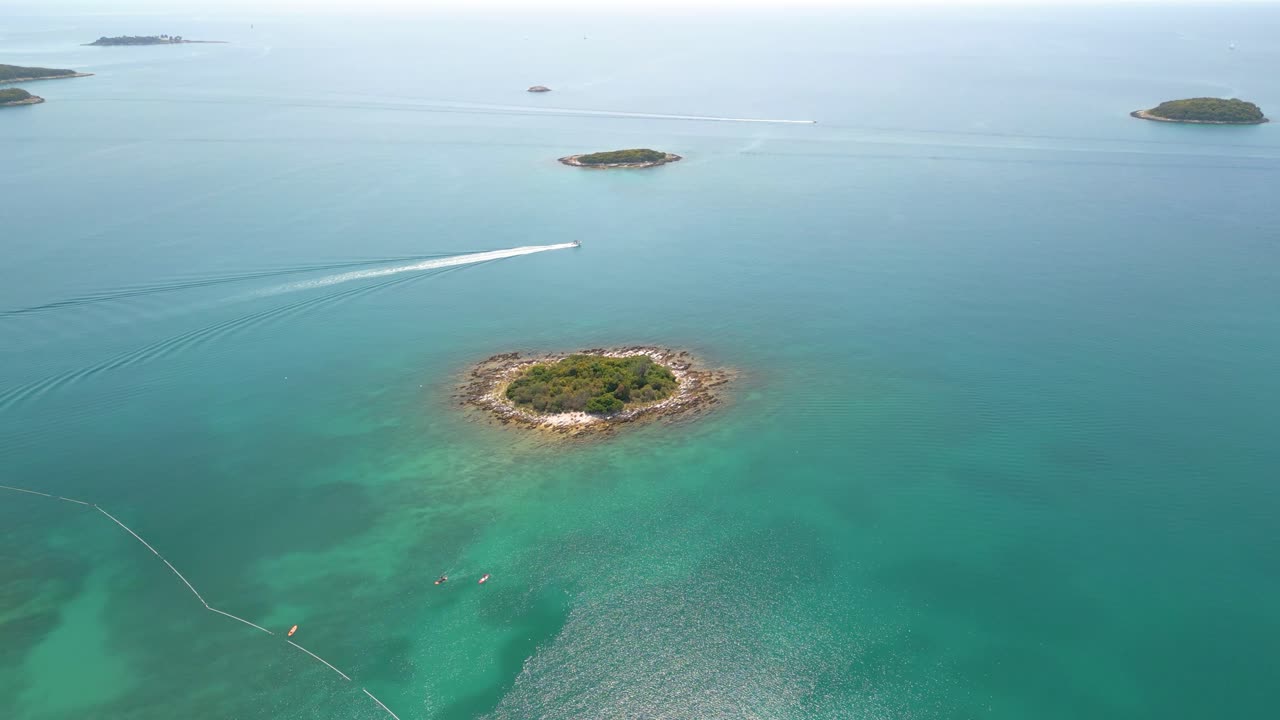 작은 열대 섬, 섬 호핑 및 자연 탐험과 함께 깨끗한 푸른 맑은 바닷물을 건너는 빠른 보트의 공중
