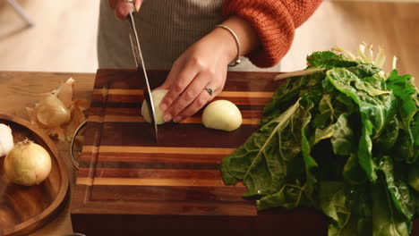 woman chopping onion and green leaves for a healthy recipe