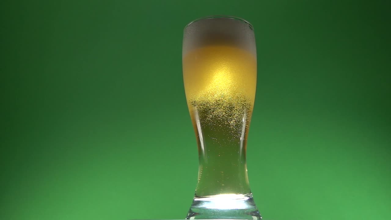 espuma de cerveza en la parte superior de un vaso de cerveza recientemente vertido