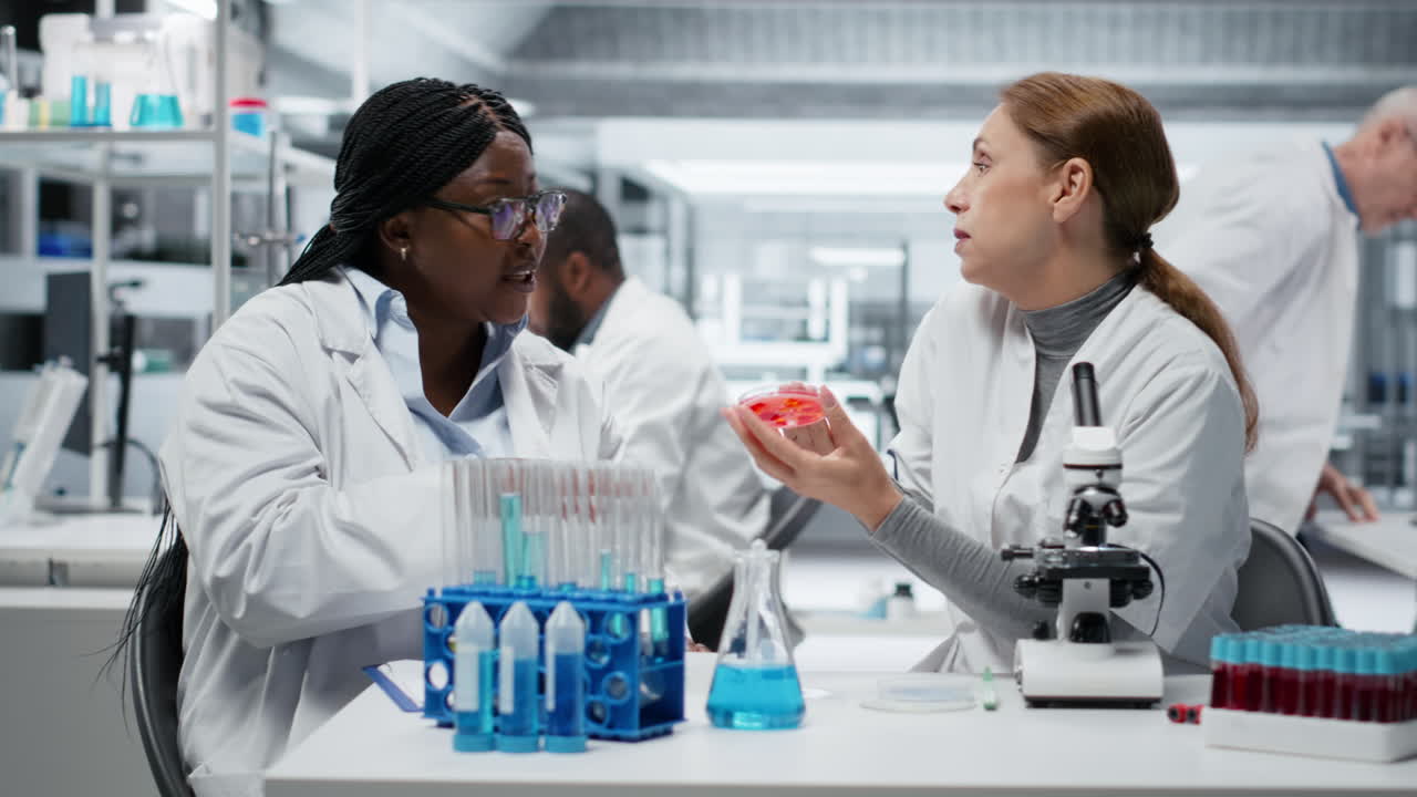 Team of laboratory researchers evaluating pharmaceutical compound in petri dish