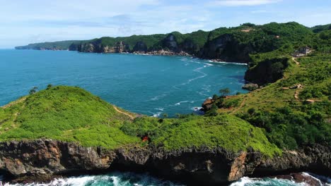 Sheer-cliffs-and-azure-ocean-aerial-panorama,-Kesirat,-Yogyakarta-Indonesia