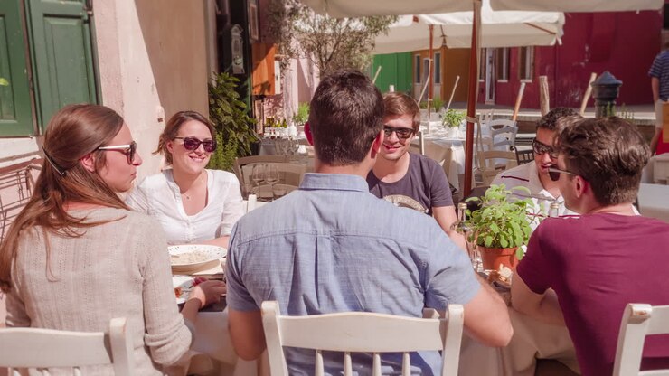 amigos disfrutando de una comida al aire libre en un café veneciano