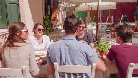 friends enjoying a meal outdoors in a venetian cafe