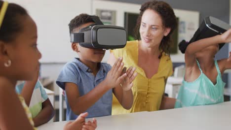 video of happy caucasian female teacher and african american pupils wearing vr headsets