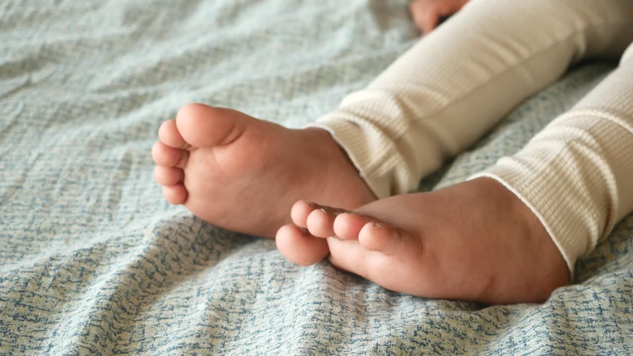 Baby feet on a bed