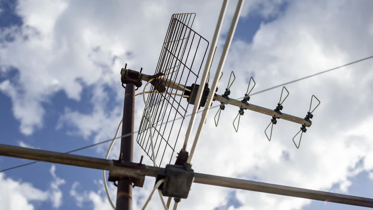 A timelapse of the sky and clouds with television aerials in the foreground