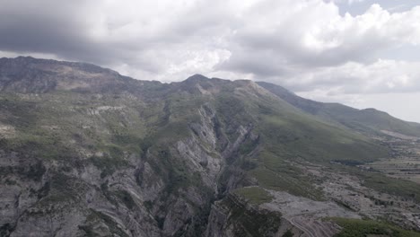 Drohnenvideo-Des-Beschreibenden-Schwenkens-über-Den-Bergpass-„Rrapsh-Serpentine“-Auf-Der-Straße-Sh20-In-Grabom,-Albanien,-Leqet-E-Hotit-Sie-Können-Dorfhäuser-Und-Fahrzeuge-Sehen