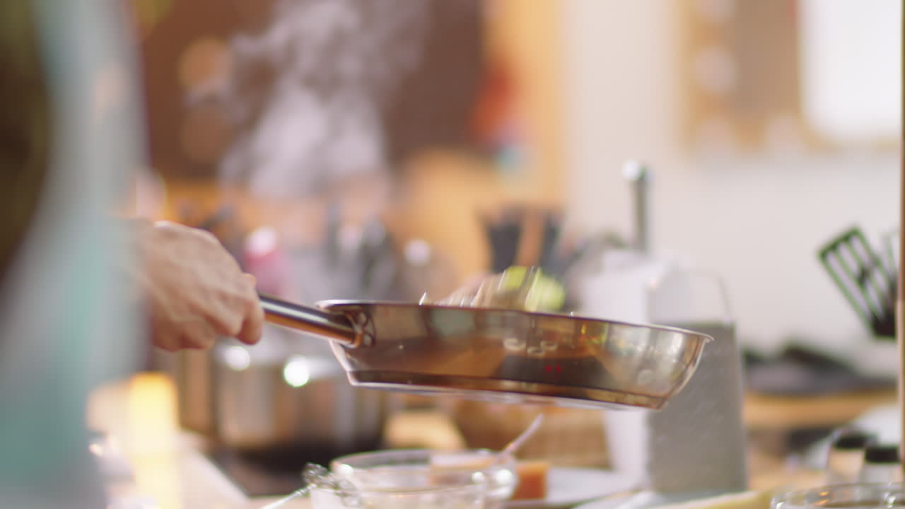 요리사는 기 동안 팬에 채소를 던지고 있습니다.