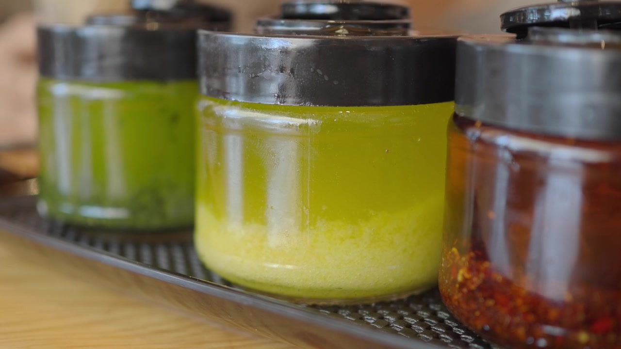 Variety of Condiment Jars with Chili Oil, Garlic, and Green Sauce