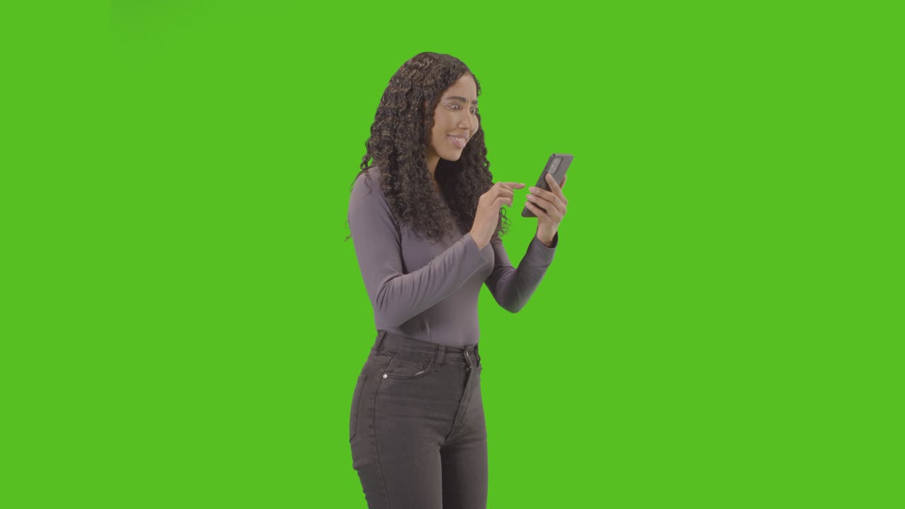 Woman Looking At Mobile Phone And Celebrating Good News Against Green Screen 6