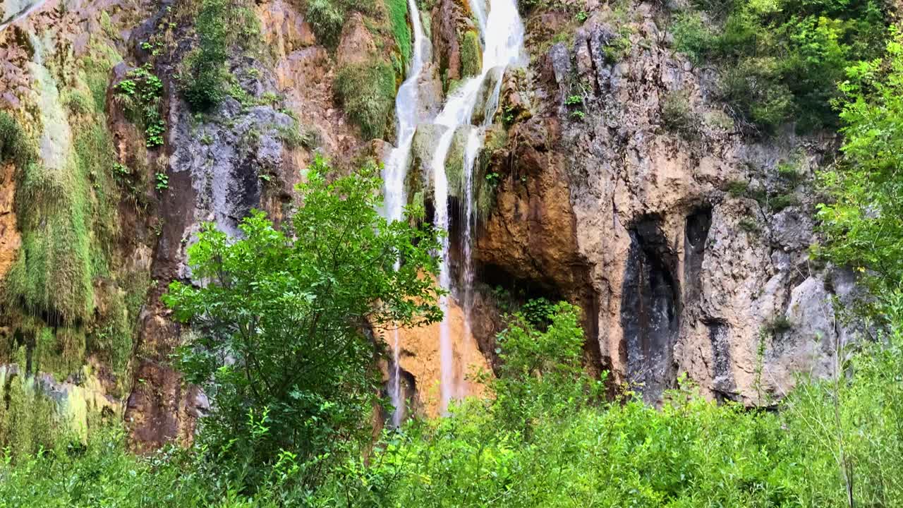 tiro inclinado hacia abajo de la majestuosa cascada pintoresca, follaje exuberante en la parte superior, parque nacional de los lagos de plitvice