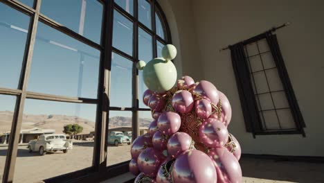 abstract art installation with pink and green balls