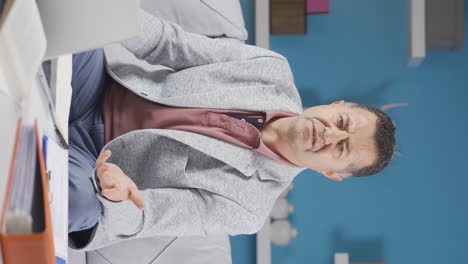 vertical video of home office worker old man nods to the camera, says no, no.