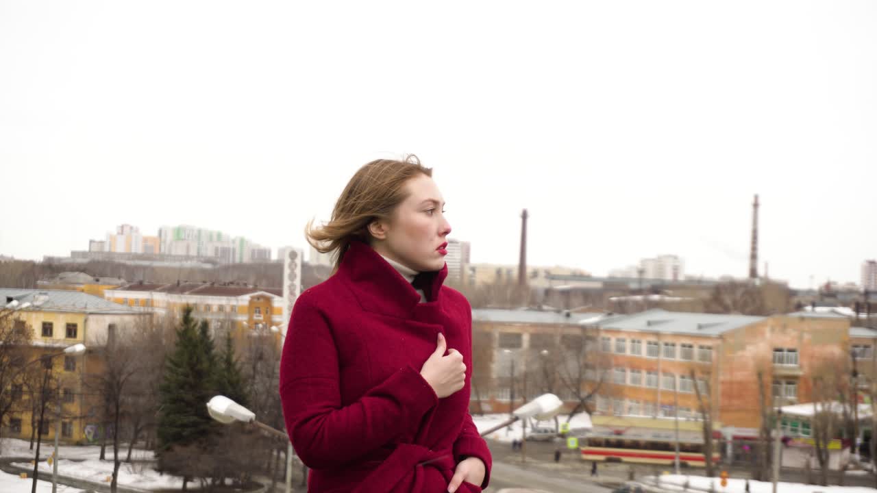 женщина в красном пальто в городе