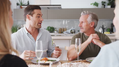 Familia-Con-Padres-Mayores-E-Hijos-Adultos-Comiendo-Juntos-Alrededor-De-La-Mesa-En-Casa