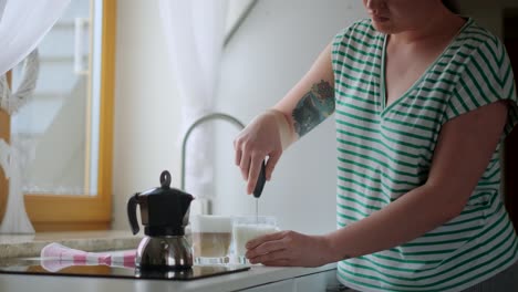 woman making latte in kitchen