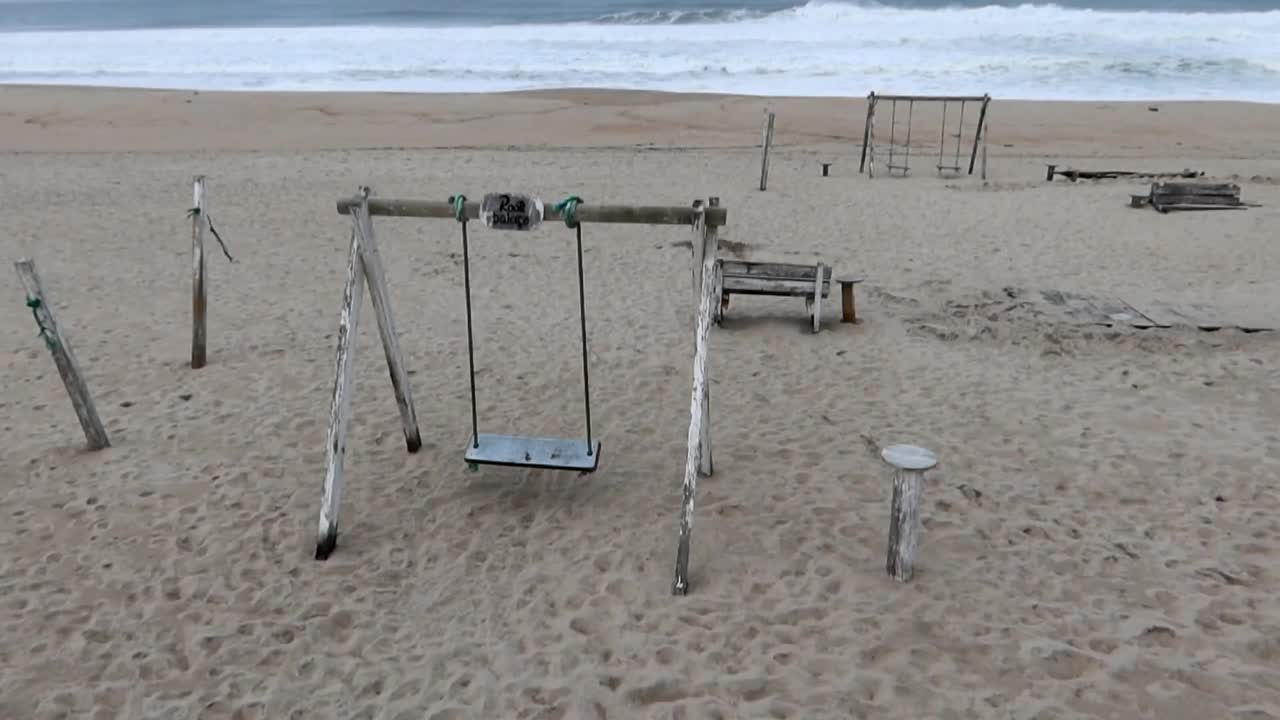 estructuras de madera y columpios en la playa de costa nova en un día nublado con condiciones marinas turbulentas