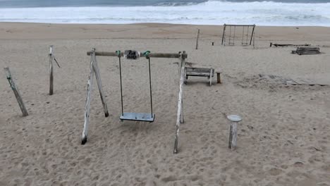 wooden structures and swings at costa nova beach on a cloudy day with turbulent sea conditions