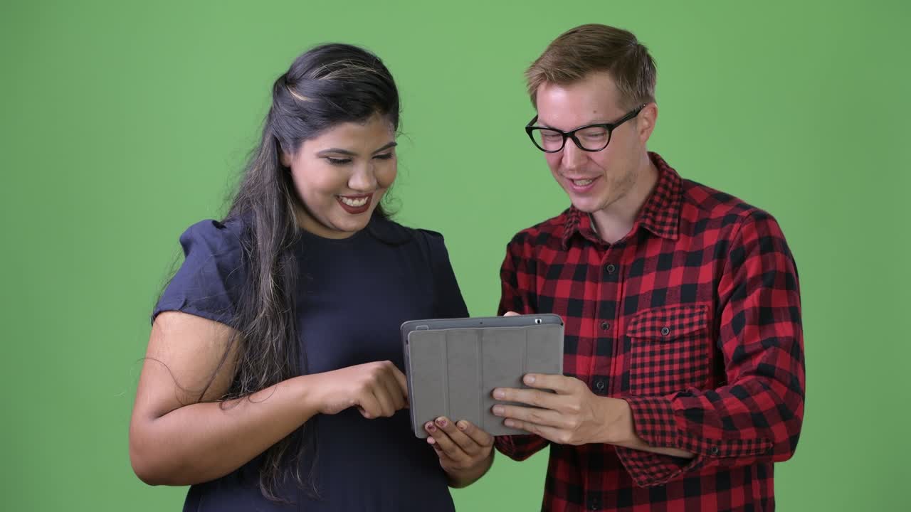 joven pareja de negocios multiétnica juntos contra un fondo verde