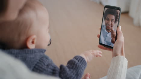 mother and baby using smartphone having video chat with father waving at infant on screen enjoying communicating with family on mobile phone connection 4k