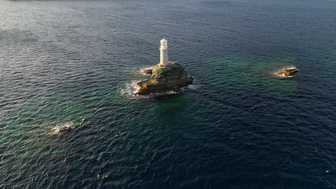 그리스 키클라데스 섬 안드로스 섬의 상징적인 등대 영상 (aerial view video of iconic lighthouse in andros island chora, cyclades, greece at dusk)