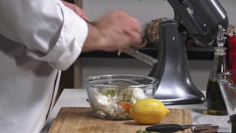 a chef prepares delicious dishes using fresh vegetables, cheese, and lemons in a clean, contemporary kitchen. the mixer adds convenience to the cooking process
