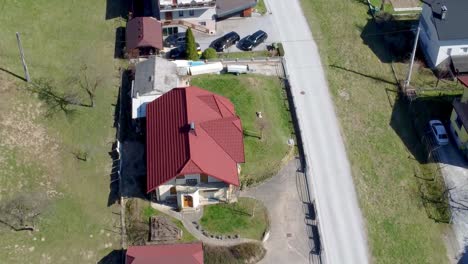 street with detached villa homes in slovenian village, top, aerial backward