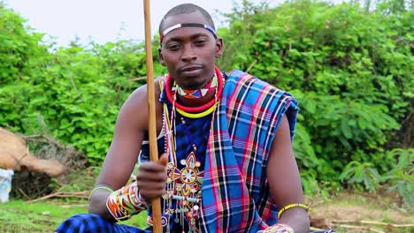 determined young moran clapping rhythm with his stick, wearing cultural gear