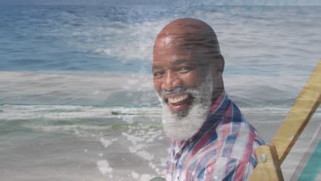 Animation-of-happy-senior-african-american-man-sitting-at-beach-over-sea