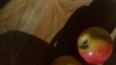 apple on a wooden surface with shadows