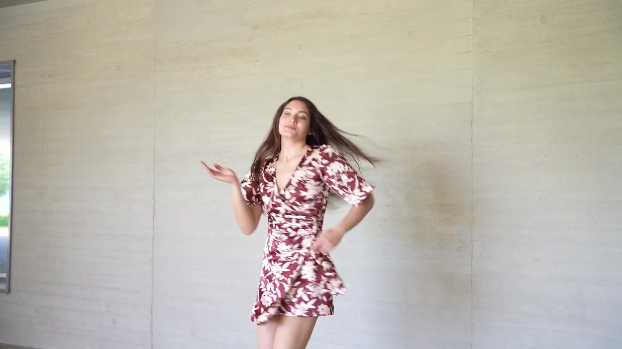 Una danza gioiosa con un bellissimo vestito floreale su uno sfondo neutro e calmo.