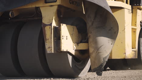 compaction roller smoothens newly paved road in neighborhood