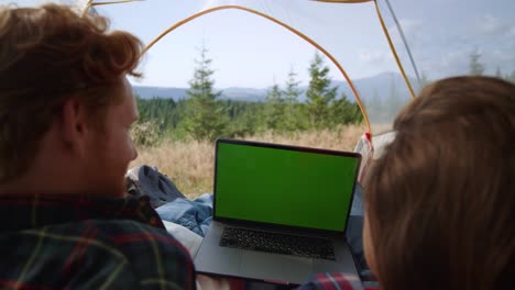 guy and girl looking at laptop screen with chroma key. friends watching film