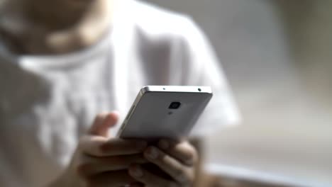 niño usa el teléfono en un ascensor en movimiento, manos adolescentes enviando mensajes de texto en el teléfono inteligente
