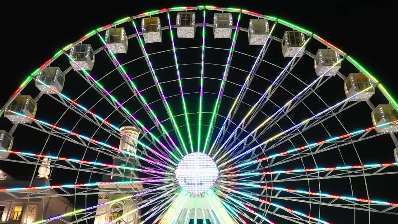 밝은 불빛으로 조명된 페리스  놀이가 밤에 카니발, 놀이 공원, 테마 공원, 박람회에서 회전합니다.