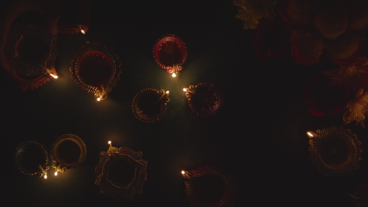Diwali Festivali'ni Kutlayan, Karartılmış Masada Diya Yağ Lambalarını Yakan Ellerin Yukarıdan Görünümü