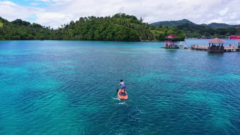 male tourist paddles toward the water cottages in tagbak marine park in liloan, southern leyte