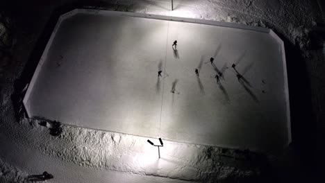 drone shot from above of a hockey rink with a game going on in winter in montreal