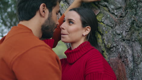 retrato de una pareja romántica cerca de un árbol mirándose el uno al otro con amor.