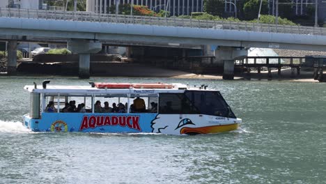 aquatic bus moving under a bridge on river